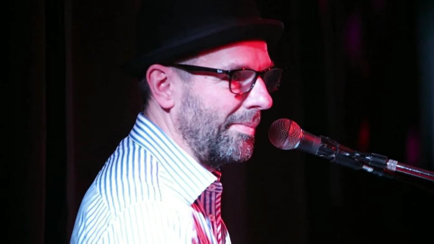 Mike Dupp playing a two-keyboard live setup in an archive performance photograph