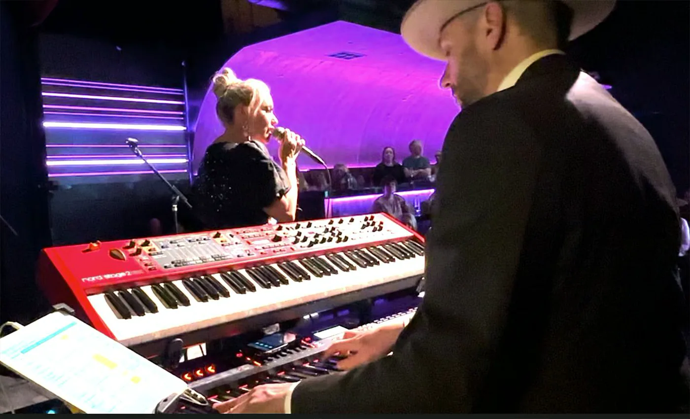 Michelle Morrison singing while Mike Dupp plays keyboards during an Adele Show performance