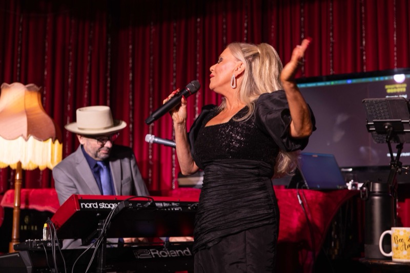 Michelle Morrison singing beside the keyboard player