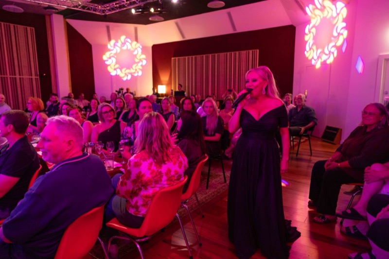 Michelle Morrison walking through the room while singing