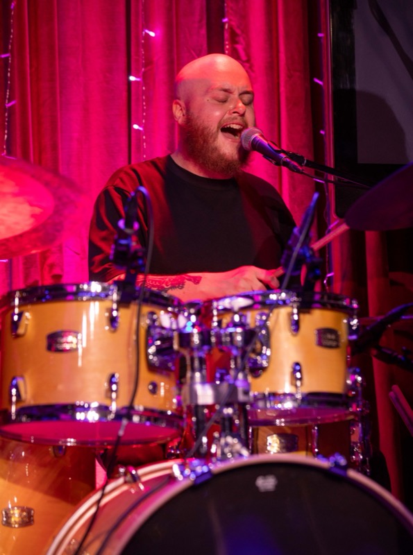 The drummer singing along behind the kit