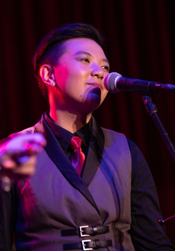 Backing vocalist in a waistcoat at the microphone